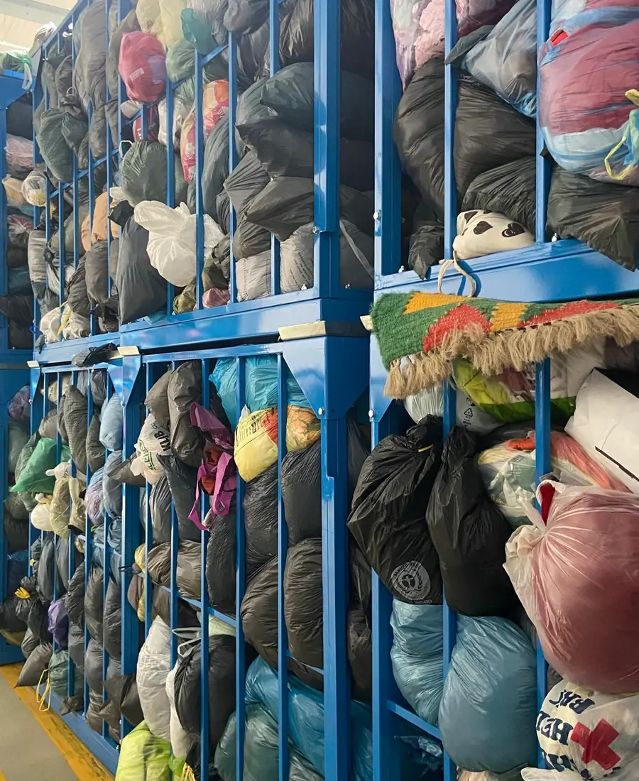 Bags of unsorted clothes in metal mesh boxes